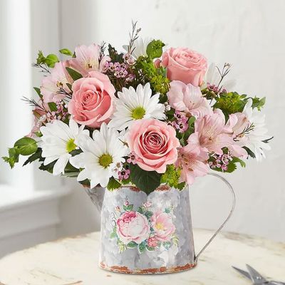 Everyone deserves some delight in their day. Our sweet bouquet is filled with a mix of pink and white blooms, designed in our vintage-inspired watering can. With its pretty peony flower and rustic charm, it’s the perfect gift to shower them with love.
<ul>
 	<li>All-around arrangement with pink roses and Peruvian lilies (alstroemeria), white daisy poms and purple waxflower; accented with assorted greenery</li>
 	<li>Arrangement measures approximately 10"H x 5.5"W</li>
 	<li>Artistically designed in our exclusive, vintage-inspired watering can, with a gorgeous peony flower; reminiscent of rustic farmhouse style; measures 4.5"H x 5"W</li>
</ul>