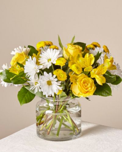 <p>This arrangement features a vibrant blend of yellow and white flowers that evoke the warmth of sunlight filling a room. Sunny yellow lilies and roses bring golden tones of happiness, while crisp white daisies and complementary blooms add a soft, peaceful balance.</p>