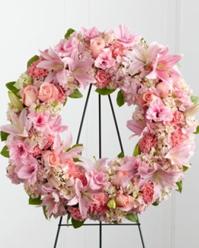 <p>This delicate wreath offers a gentle and dignified way to honor a life filled with warmth, compassion, and grace. A graceful mix of soft pink roses, fragrant Oriental lilies, elegant gladiolus, full hydrangea, and delicate carnations are thoughtfully arranged with fresh, verdant greenery.</p>