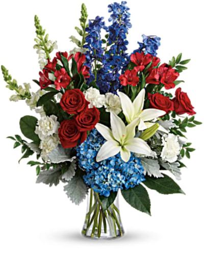 <p>This bouquet features a striking mix of red roses, white Asiatic lilies, blue hydrangea, red alstroemeria, white carnations, blue delphinium, and white snapdragons. Accented with huckleberry, dusty miller, aralia leaf, and lemon leaf, the arrangement offers rich texture and fullness.</p>