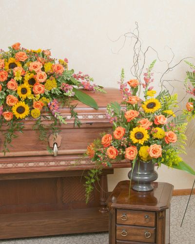 <p>Honor a beautiful life with the warm, peaceful tones of a setting sun. The set includes a coordinating casket spray, standing spray, and urn arrangement, all crafted in rich sunset hues.</p>