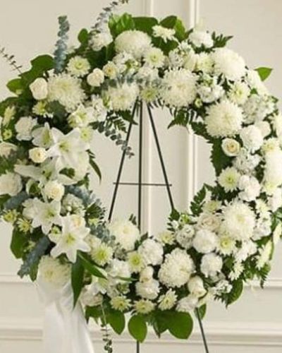 <p>Honor a life of love, dignity, and grace with the timeless beauty of the Serene Sympathies Standing Wreath in white. Handcrafted by expert florists, this standing wreath features a serene blend of fresh white roses, football mums, and carnations.</p>