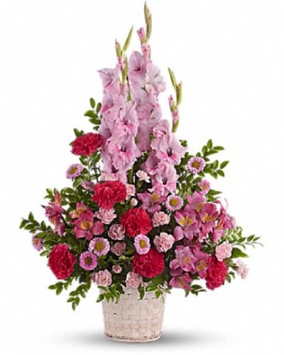 <p>This design features a delicate mix of fresh pink blooms, including gladioli, alstroemeria, carnations, and other seasonal flowers chosen for their freshness and soothing appearance. These blossoms are hand-arranged in a classic white basket, where the soft color palette and balanced composition create an inviting presence that brings serenity and warmth to any setting.</p>