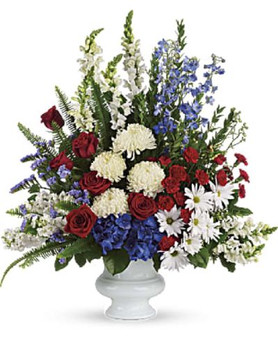 <p>Honor a life defined by service, pride, and strength with a patriotic floral tribute that conveys enduring courage and timeless love. The arrangement includes rich hydrangea, elegant roses, miniature carnations, snapdragons, chrysanthemums, and seasonal accent blooms, all thoughtfully composed to reflect solemn tribute and deep emotion.</p>
