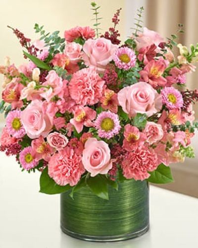 <p>This vibrant pink arrangement features a graceful mix of fresh roses, spray roses, snapdragons, alstroemeria, carnations, asters, and heather. The flowers are thoughtfully arranged in a clear glass cylinder vase and finished with a Ti leaf ribbon for a soft, modern presentation.</p>