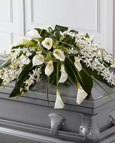 <p>Honor a loved one with elegance and tranquility through this exquisite casket spray. The arrangement features a sophisticated blend of white Dendrobium orchids and elegant calla lilies, paired with green hydrangea and a lush mix of seasonal greenery.</p>
