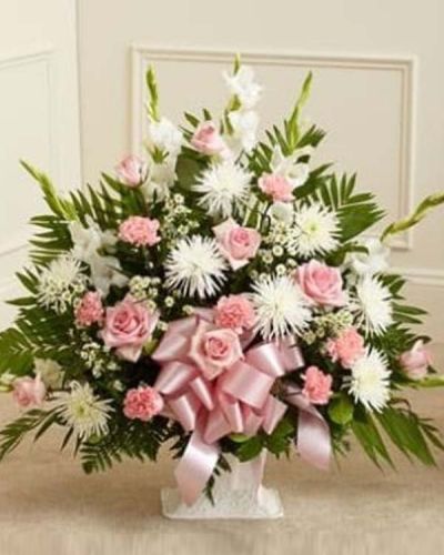 <p>The Touching Tribute Floor Basket in pink and white is a heartfelt expression of sympathy, offering peace, admiration, and comfort during times of loss. This elegant arrangement features fresh pink roses, white spider mums, white snapdragons, pink carnations, and additional seasonal blooms.</p>
