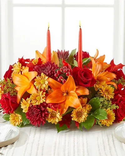 <p>Dress your table with these red roses, butterscotch daisies, and a blooming peach lily, beautifully bringing the colors of the season to your gathering.</p>