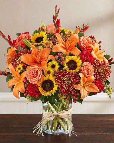 <p>This fall-inspired arrangement speaks through warm seasonal hues, offering quiet comfort and honoring a life well lived. The bouquet features a rich blend of golden sunflowers, rust-colored chrysanthemums, deep red carnations, and bronze-hued alstroemeria.</p>