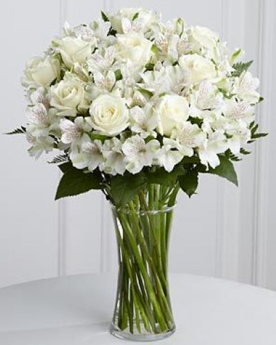 <p>The arrangement features pure white roses and soft Peruvian lilies, symbols of remembrance, reverence, and enduring friendship. White roses convey honor and respect, while lilies suggest renewal and the promise of peace.</p>