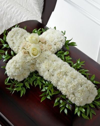 <p>Honor a life rooted in faith and love with this striking casket spray designed in the shape of a cross. Soft white roses and spray roses create a graceful focal point at the center, while pure white carnations form the full shape of the cross.</p>