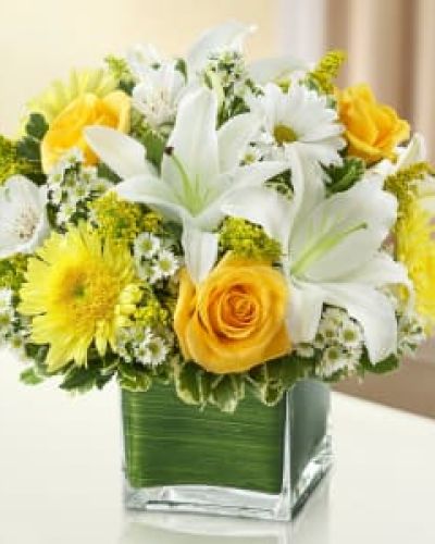 <p>This cheerful yet graceful bouquet features a vibrant mix of yellow and white flowers, including roses, lilies, cremones, alstroemeria, daisy poms, and golden solidago. Hand-arranged in a modern cube glass vase, the design is compact yet full of color and life—ideal for a side table, hospital room, or any space needing a lift in spirit.</p>