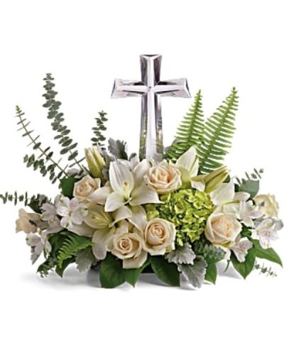 <p>The serene bouquet features a graceful mix of green hydrangea, crème roses, white Asiatic lilies, and white alstroemeria. Accented with dusty miller, sword fern, spiral eucalyptus, and lemon leaf, it is thoughtfully adorned with a crystal cross keepsake that adds a meaningful touch.</p>