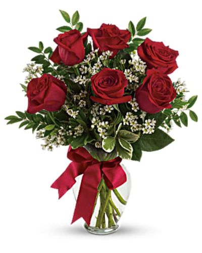<p>This bouquet features striking red roses paired with delicate white waxflower and accented by fresh huckleberry and pittosporum. A classic clear glass vase and bold red satin ribbon complete the look, giving the arrangement a polished yet romantic feel.</p>